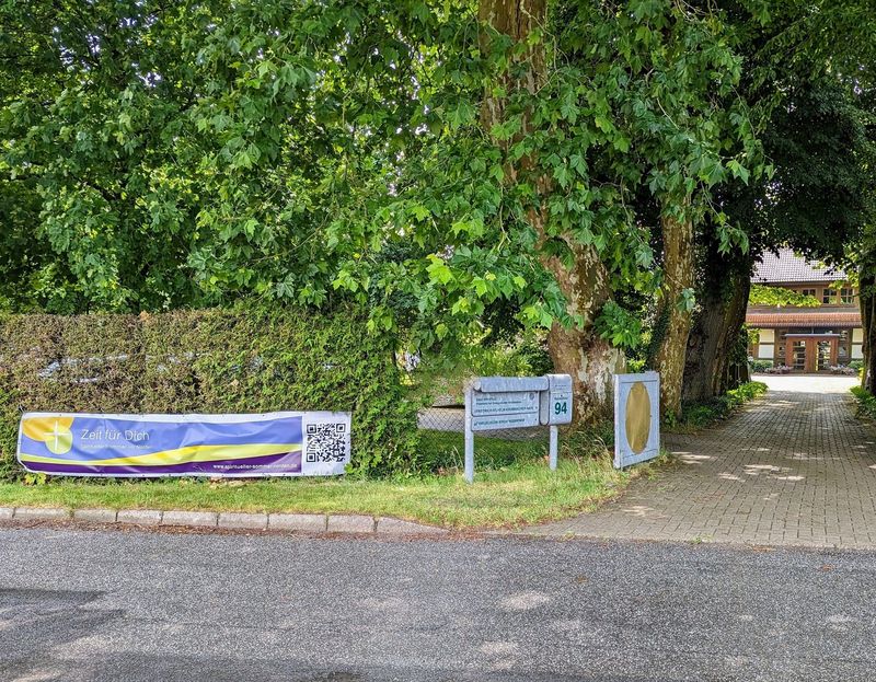 Banner "Spiritueller Sommer im Norden" vor der Einfahrt zum "Haus der Stille" in Weitenhagen.