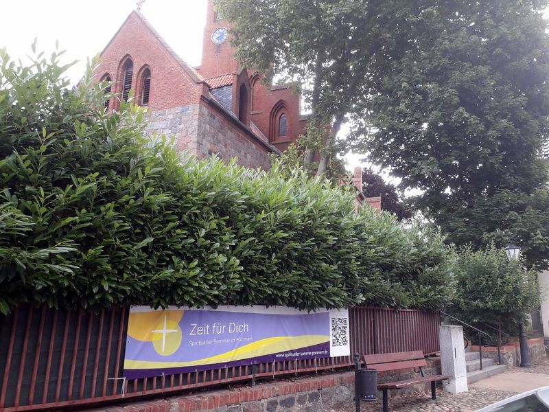 Banner "Spiritueller Sommer" vor der Marienkirche in Jarmen.